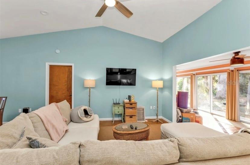 A living room features light blue walls, a sectional sofa, and a wall-mounted television — 3003 SIKESTON AVENUE, NORTH PORT, FL