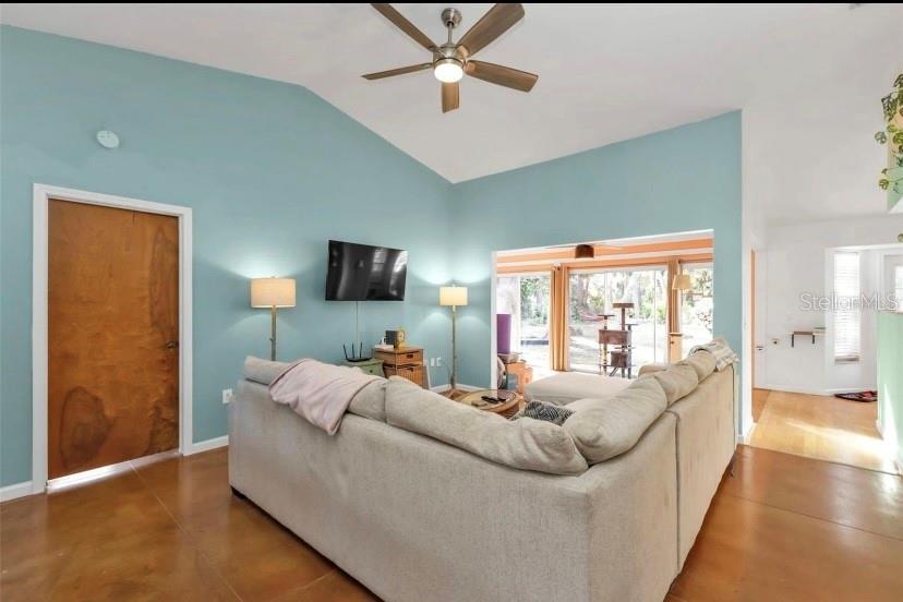 A living room features light blue walls, a vaulted ceiling, and a large sectional sofa — 3003 SIKESTON AVENUE, NORTH PORT, FL
