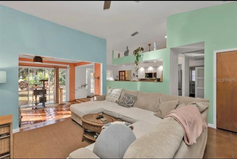 A living room features a large sectional sofa, light blue and green walls, and sliding doors — 3003 SIKESTON AVENUE, NORTH PORT, FL