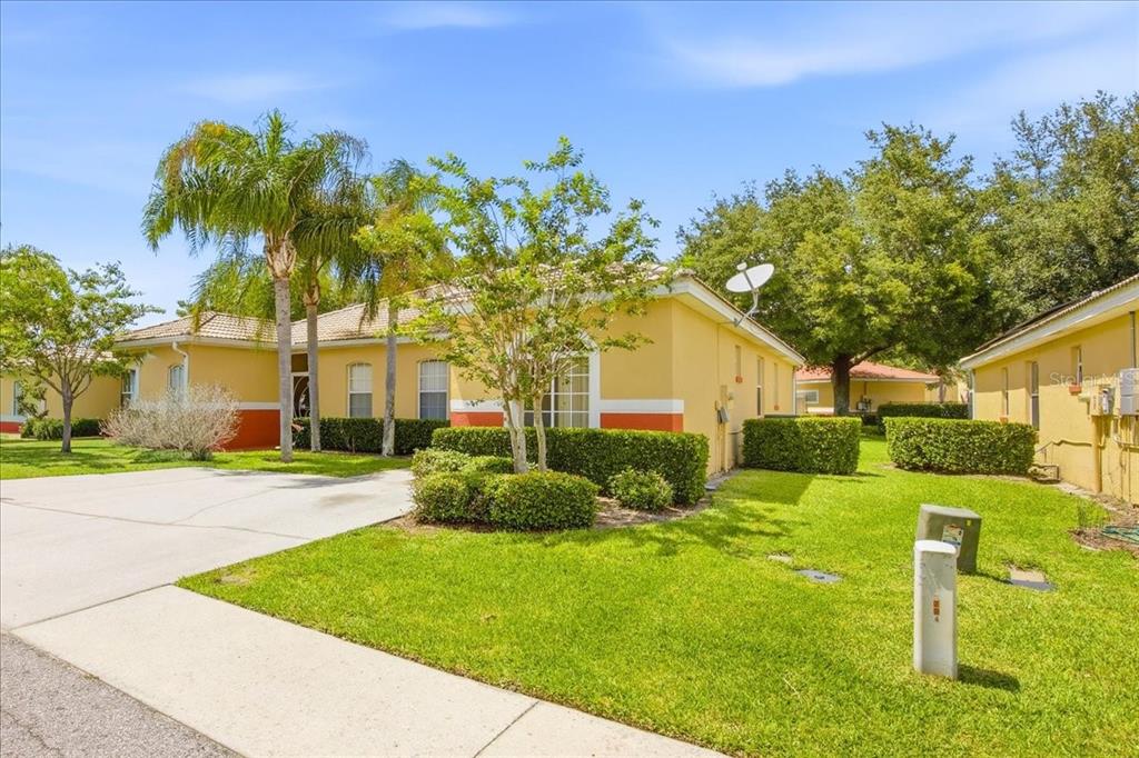 An aerial view shows a yellow house with a tiled roof and a concrete driveway — 157 OCEAN BLUFF DRIVE, POINCIANA, FL