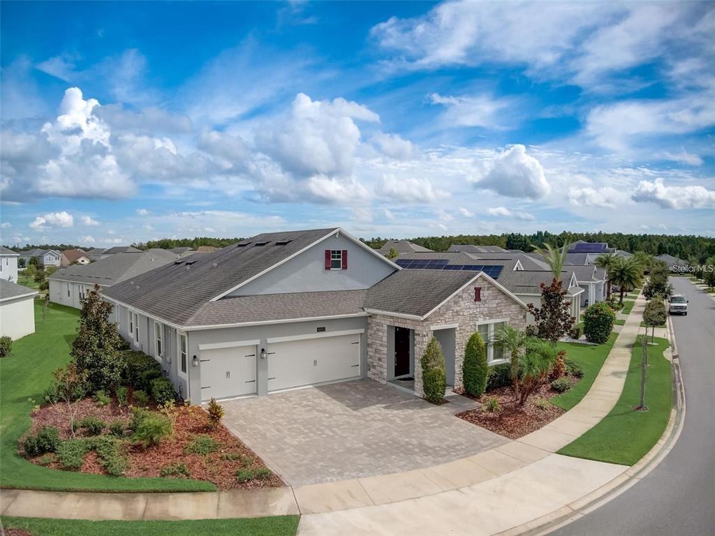 An aerial view of a single-story house with a stone facade and a paver driveway — 4693 FAIRY TALE CIRCLE, KISSIMMEE, FL
