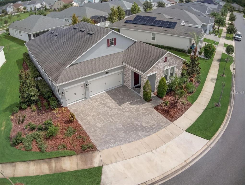An aerial view of a single-story suburban house with a paved driveway and stone facade — 4693 FAIRY TALE CIRCLE, KISSIMMEE, FL