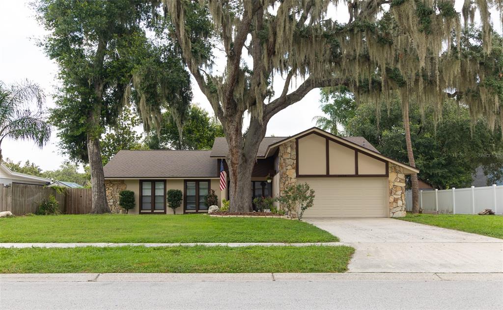 A single-story house with a stone facade, a two-car garage, and a large oak tree — 1005 TRANQUIVIEW LANE, VALRICO, FL