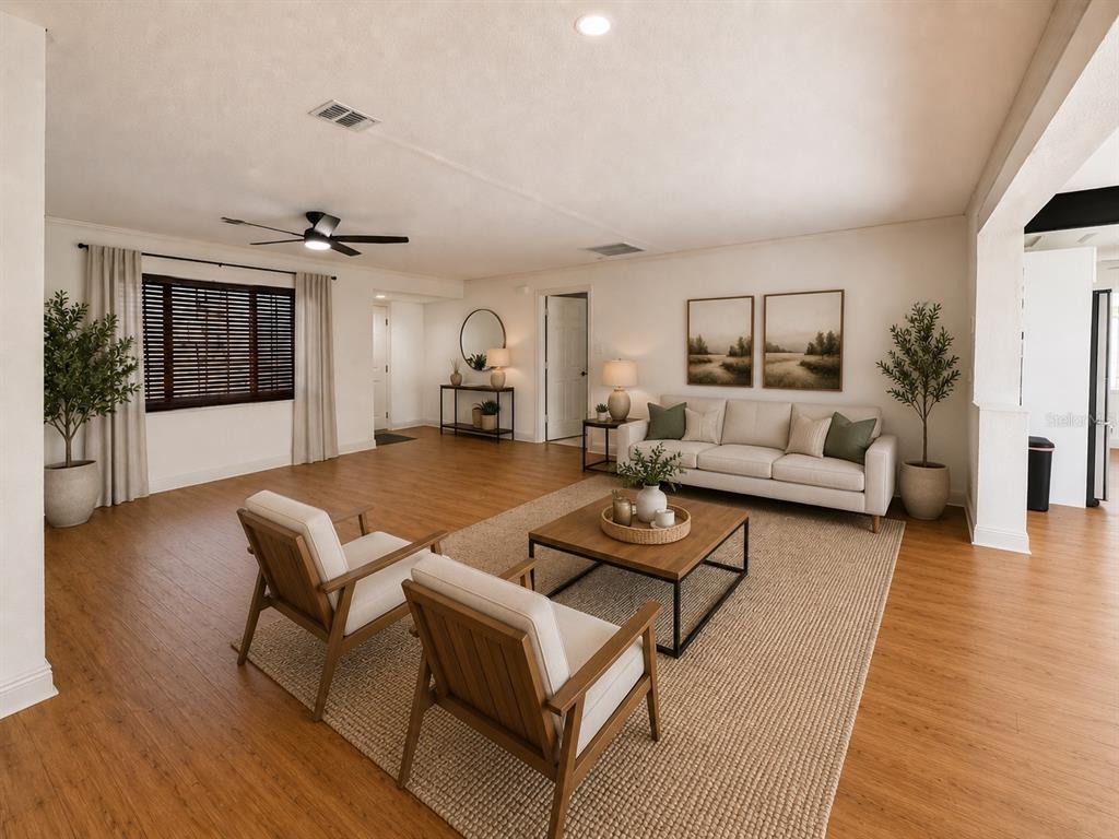 A living room features light wood flooring, a beige sofa, two armchairs, and a coffee table — 9554 86TH AVENUE, SEMINOLE, FL