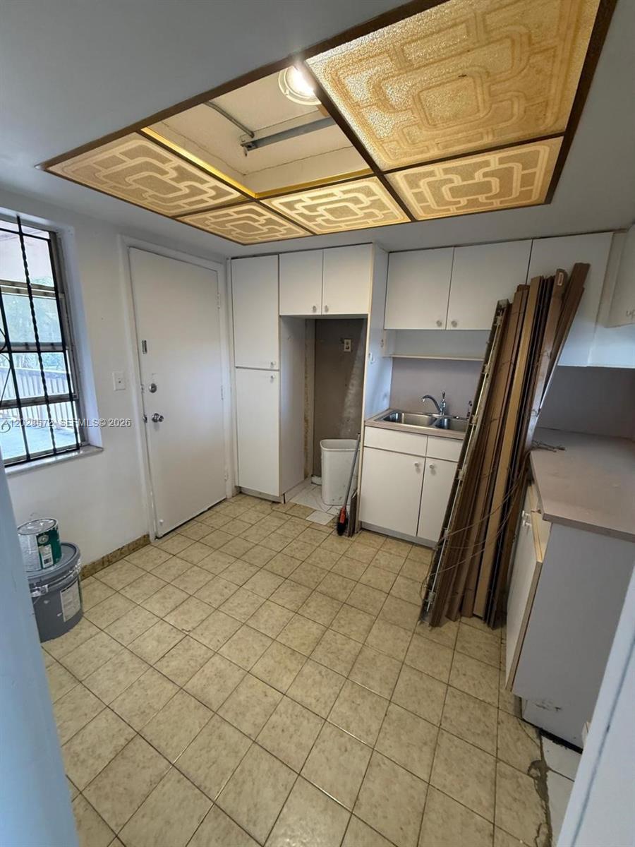 A kitchen with white cabinets, a sink, tiled flooring, and a decorative drop ceiling — 18555 NE 14th Ave # 615A, Miami FL 33179, MIAMI, FL