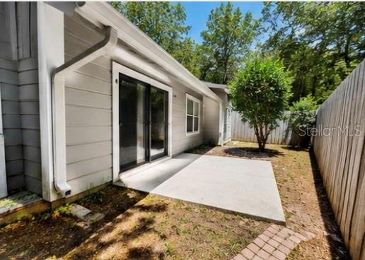 A gray single-story house with a palm tree and a paved driveway in the front yard — 3915 NW 7TH PLACE, GAINESVILLE, FL