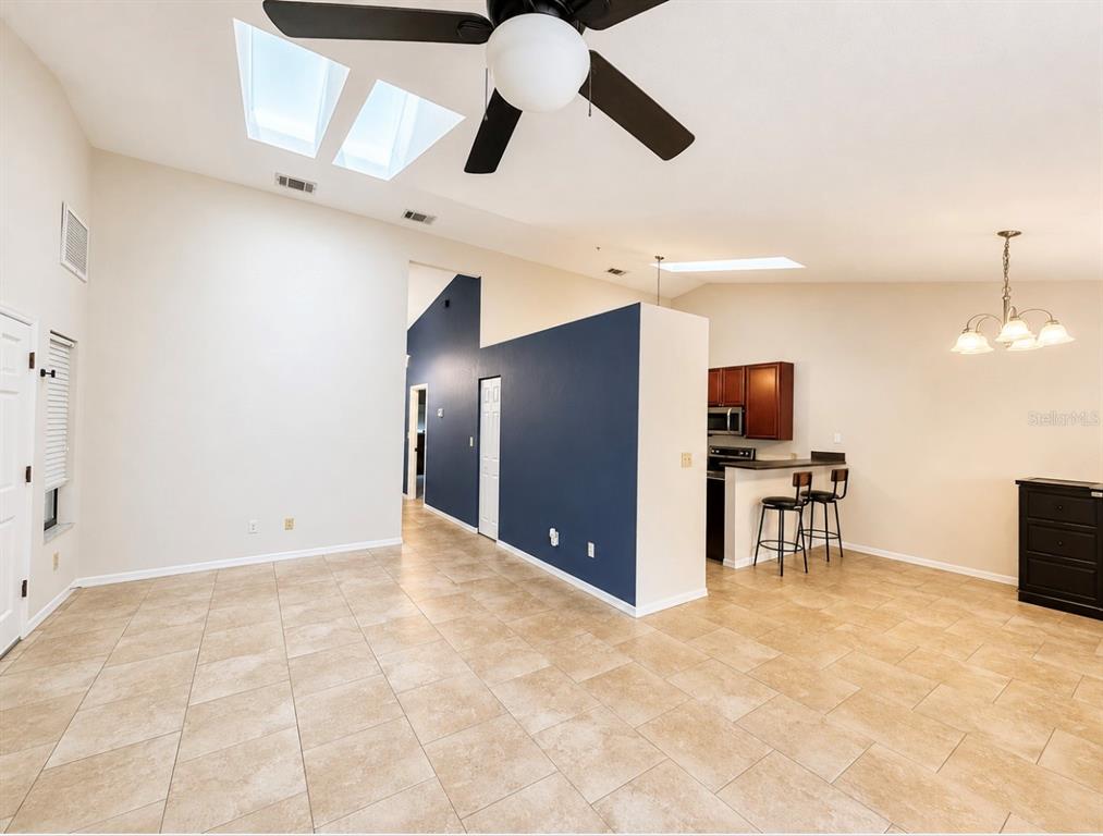 A kitchen with dark wood cabinets, stainless steel appliances, and a breakfast bar — 3915 NW 7TH PLACE, GAINESVILLE, FL