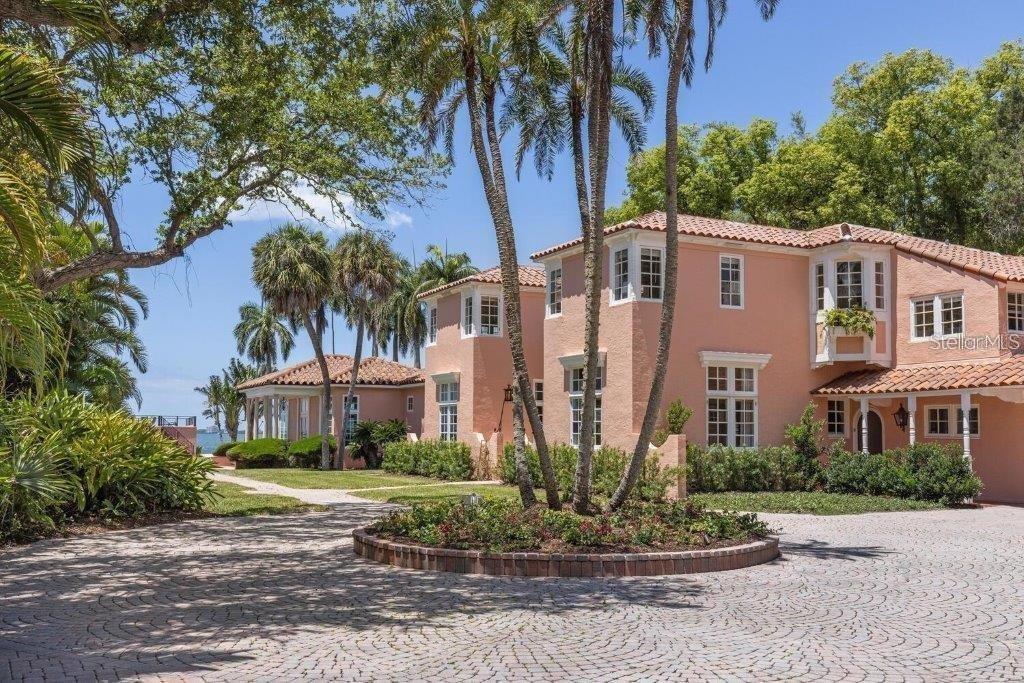 A peach-colored two-story house with a circular stone driveway and palm trees — 4511 BAY SHORE ROAD, SARASOTA, FL
