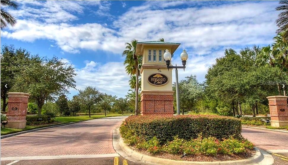 The entrance to the Hernando Oaks community features a brick monument sign and landscaping — 17589 GARSALASO CIR, BROOKSVILLE, FL