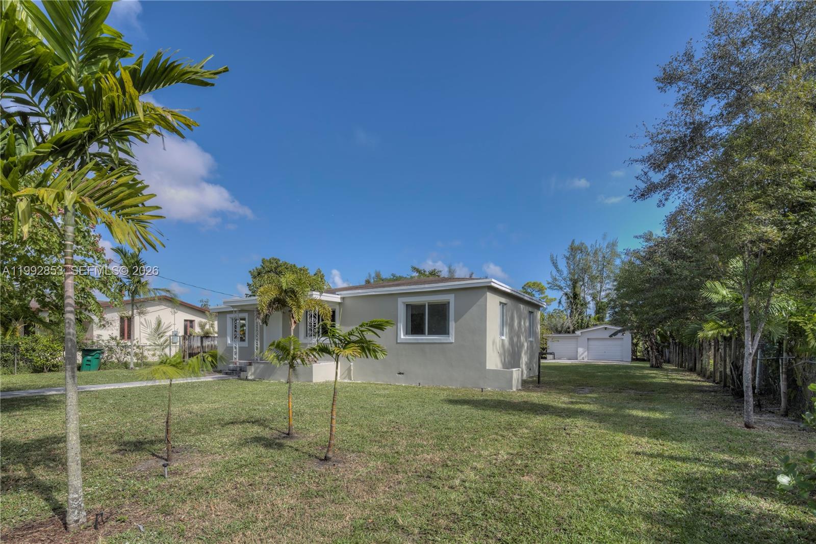 A single-story house with a light-colored exterior sits on a grassy lot with palm trees — 14115 NW 5th Ave # 1, Miami FL 33168, MIAMI, FL