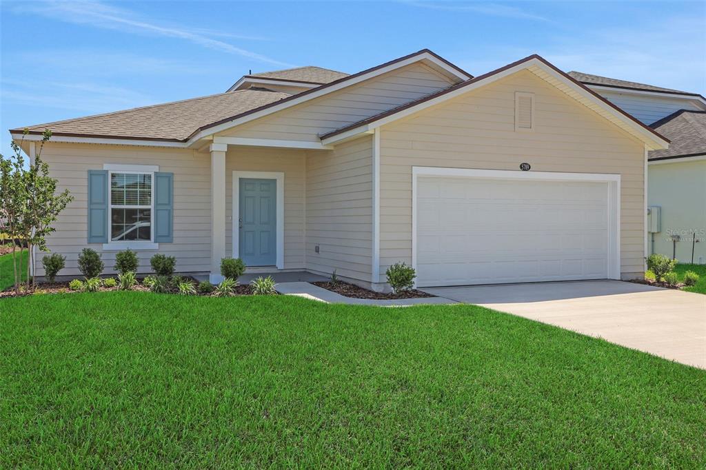 A kitchen featuring white cabinets, stainless steel appliances, a quartz countertop, and a sink island — 5700 LAGOON CRUISE WAY, JACKSONVILLE, FL