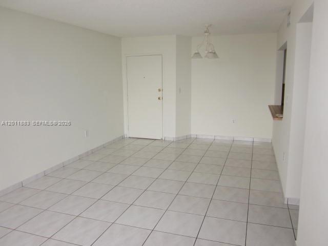 An empty room features white walls, a white door, and light-colored tiled flooring — 8201 NW 8th St # 414, Miami FL 33126, MIAMI, FL
