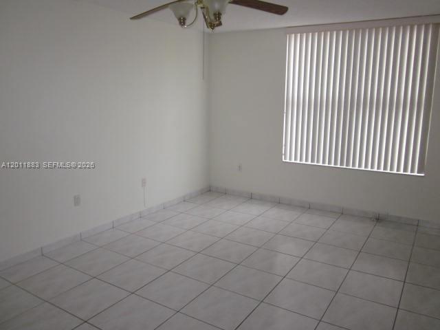 An empty room features white walls, light-colored tile flooring, and a window with vertical blinds — 8201 NW 8th St # 414, Miami FL 33126, MIAMI, FL
