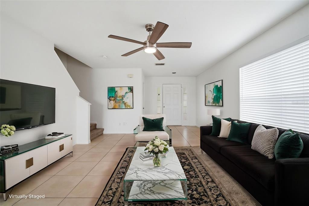 A living room with a black sofa, marble coffee table, and a ceiling fan — 10604 LAKESIDE VISTA DRIVE, RIVERVIEW, FL