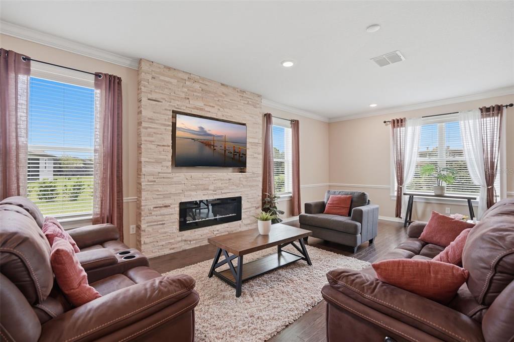 An open-concept kitchen and living area featuring dark wood cabinets, granite countertops, and hardwood floors — 9307 PARISIAN COURT, SEFFNER, FL