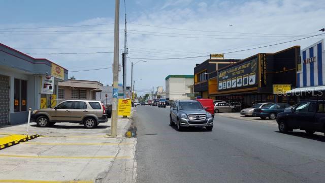 A street view showing a road with parked cars, commercial buildings, and a utility pole — 404 ANDALUCIA, SAN JUAN, PR