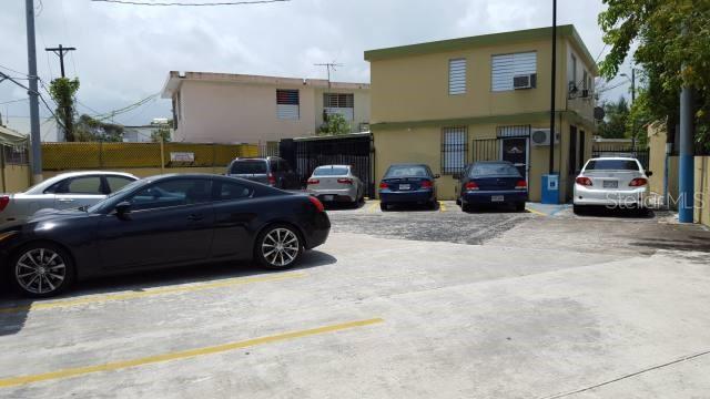 A paved parking lot with several parked cars in front of a two-story building — 404 ANDALUCIA, SAN JUAN, PR