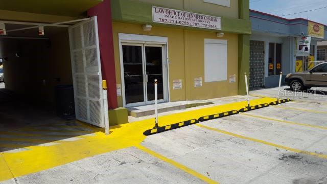 The exterior of a commercial building features a yellow-painted walkway and parking area — 404 ANDALUCIA, SAN JUAN, PR