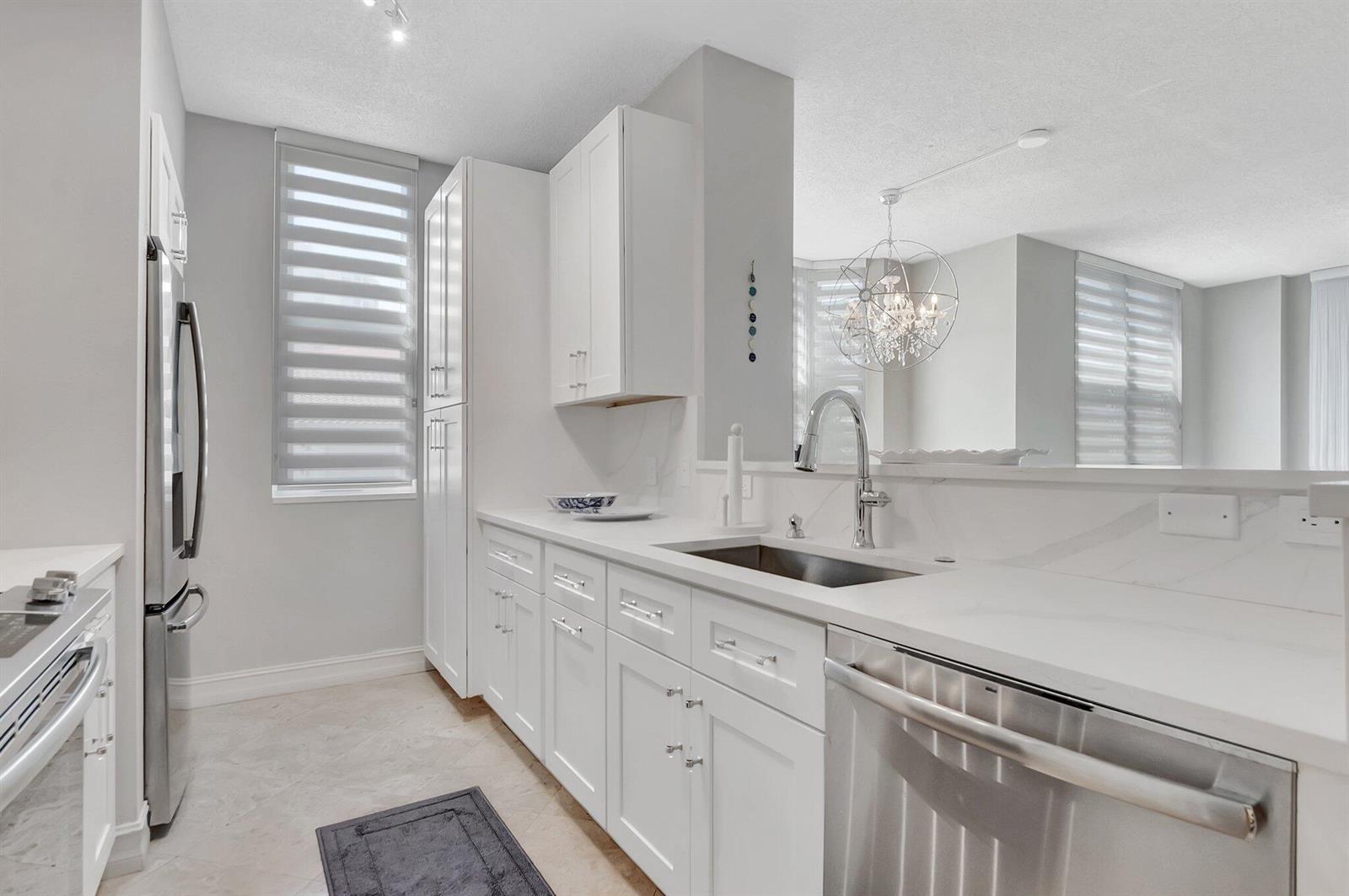 A modern kitchen with white cabinets, stainless steel appliances, and quartz countertops — 3606 S Ocean Boulevard # 108, Highland Beach FL 33487, HIGHLAND BEACH, FL