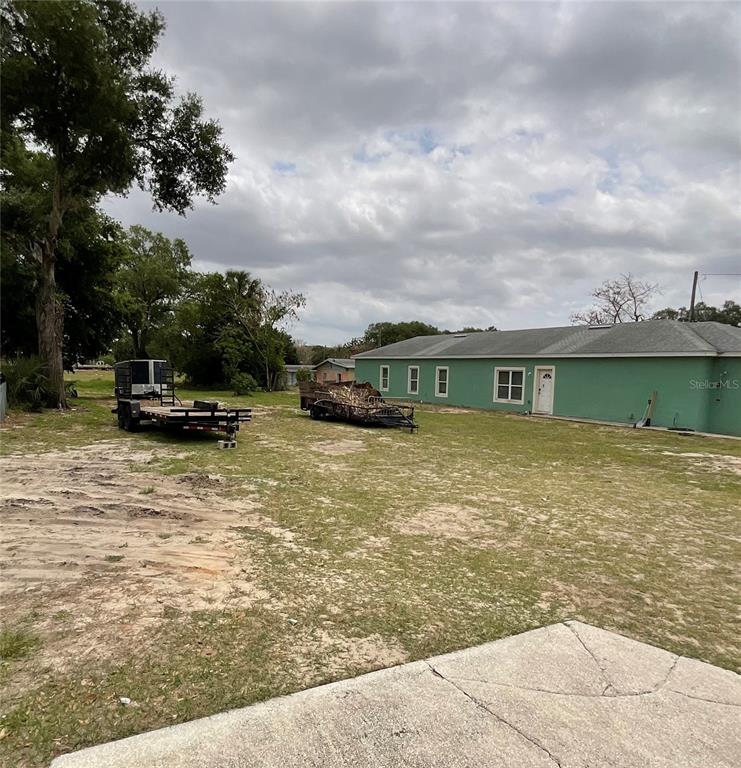 A green house stands on a large, grassy lot with two trailers parked outside — 480 D STREET, LAKE WALES, FL