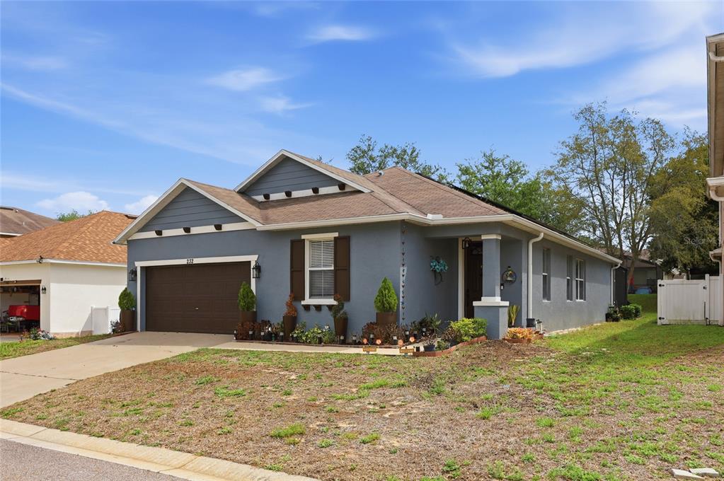 A single-story blue house with a brown garage door and a front-facing gable roof — 232 ALDRIDGE LANE, DAVENPORT, FL