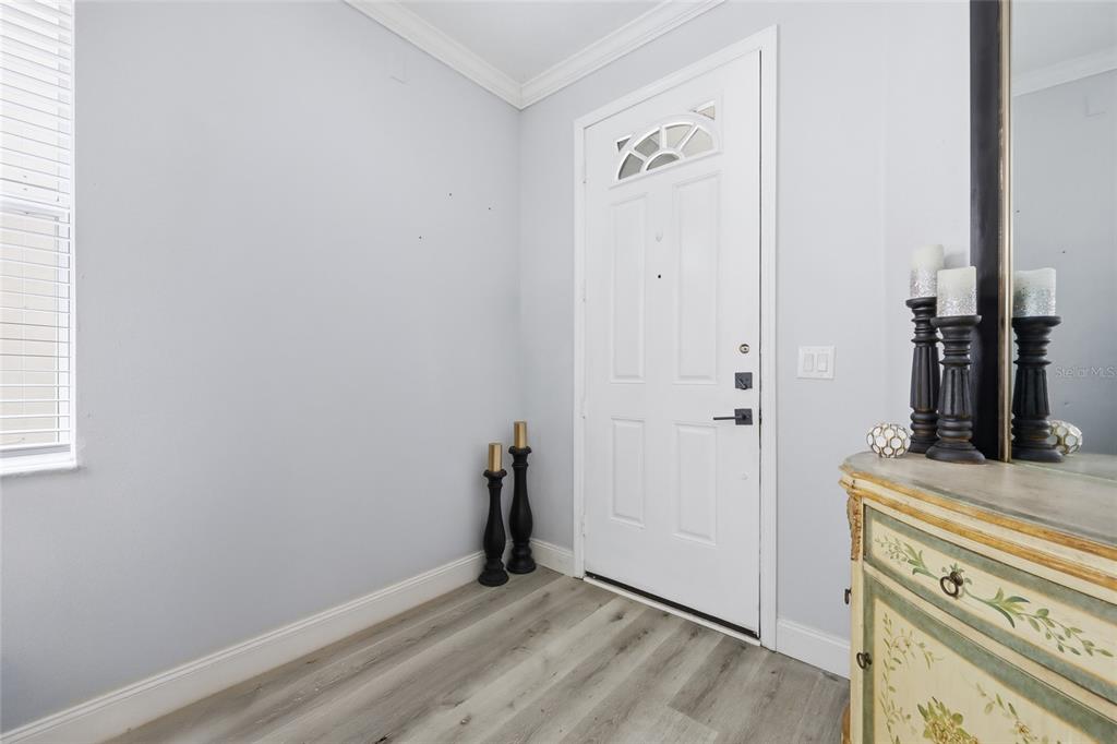 An entryway features light gray walls, wood-look flooring, a white front door, and a dresser — 232 ALDRIDGE LANE, DAVENPORT, FL