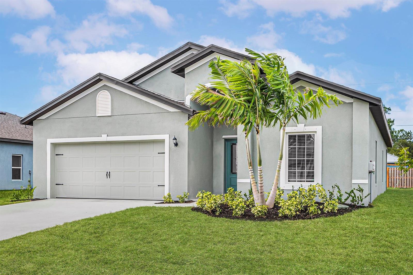 A single-story house with a gray stucco exterior, a two-car garage, and a palm tree — 8416 100th Avenue, Vero Beach FL 32967, VERO BEACH, FL