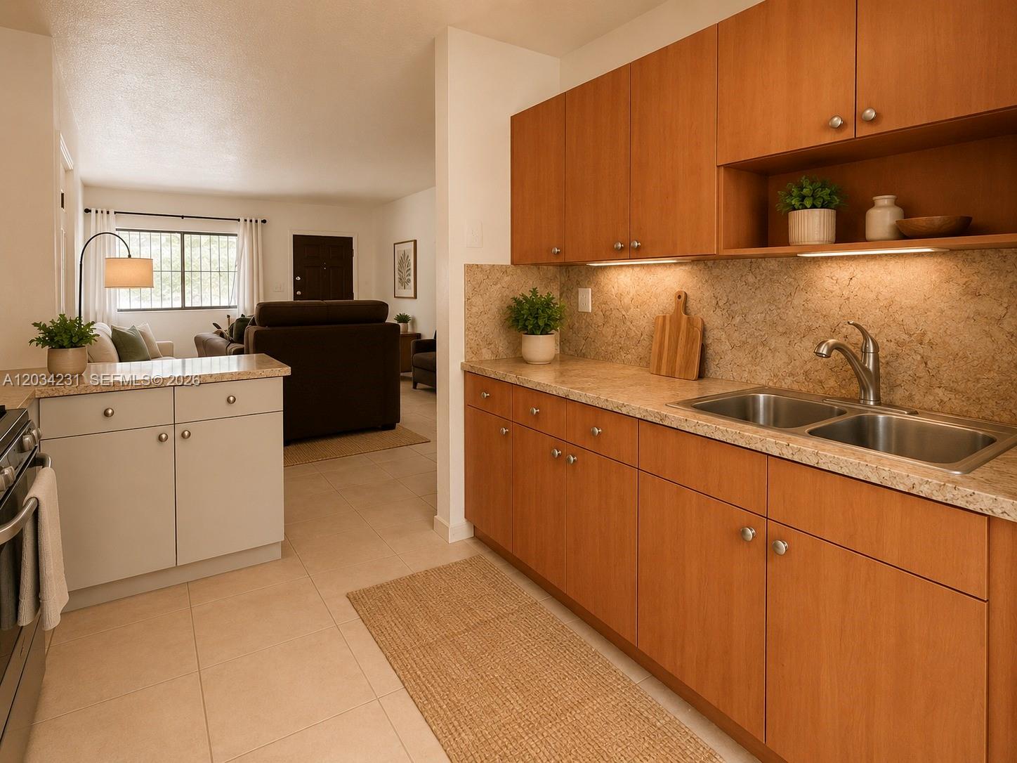 A kitchen with wood cabinets, light countertops, and a sink opens to a living area — 2775 W 61st St # 102, Hialeah FL 33016, HIALEAH, FL
