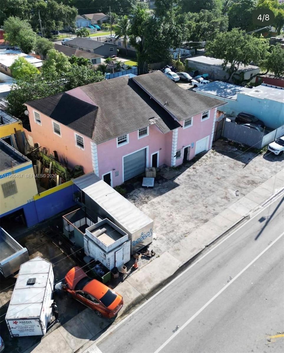An aerial view shows a pink two-story building with a garage and a paved lot — 3067 NW 54th St, Miami FL 33142, MIAMI, FL