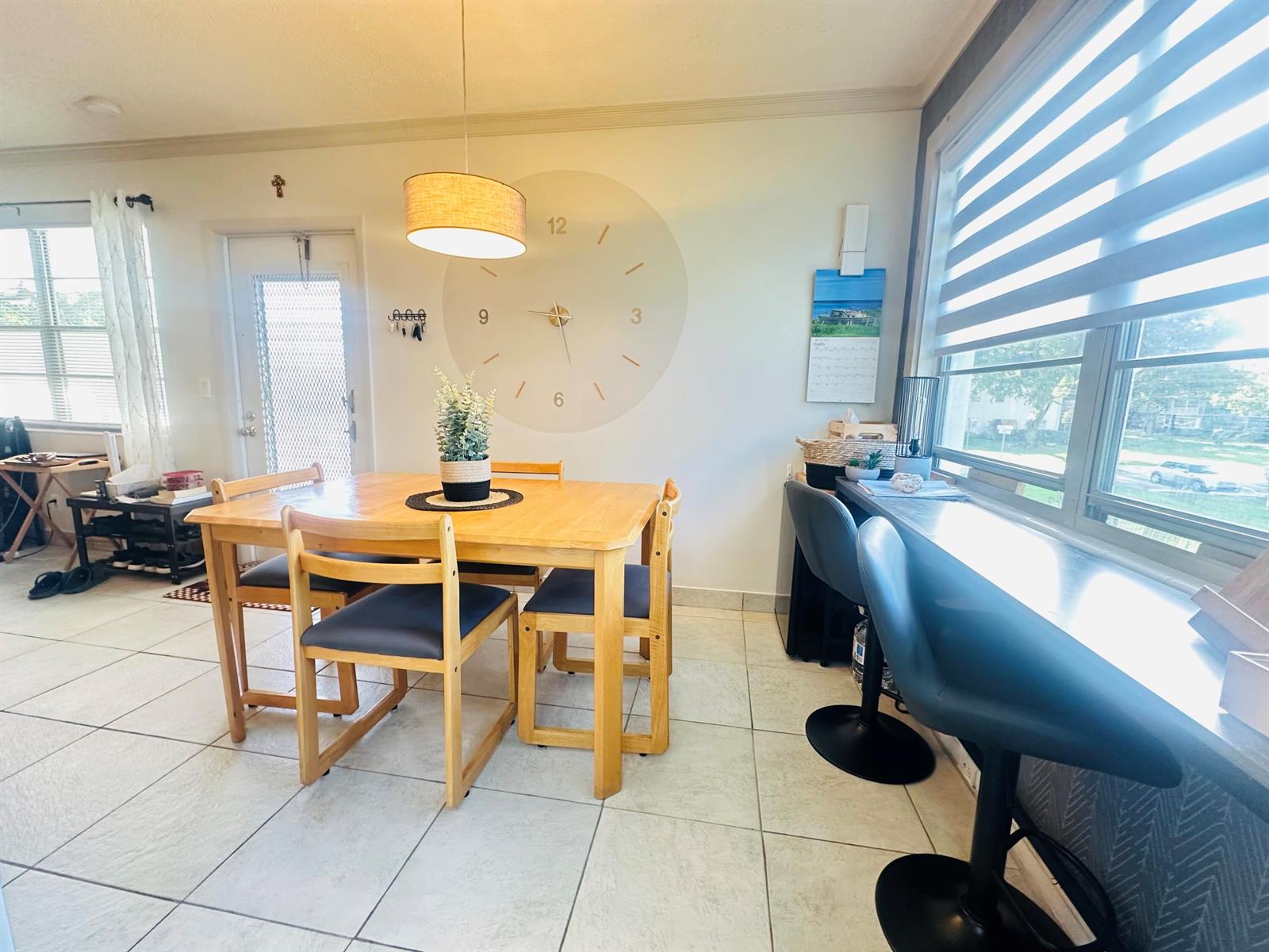 A dining area features a wooden table with four chairs, a wall clock, and a window bar — 200 Ventnor L # 200, Deerfield Beach FL 33442, DEERFIELD BEACH, FL