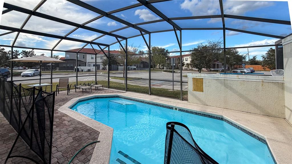 A screened-in patio features a swimming pool, brick pavers, and outdoor furniture — 4523 ALBERTO CIRCLE, KISSIMMEE, FL