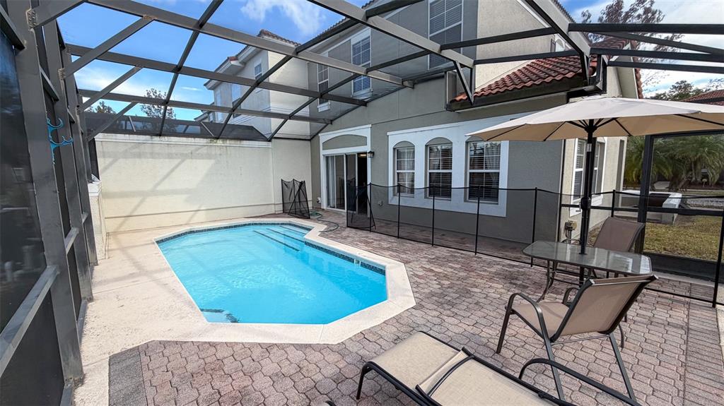 A screened-in patio features a swimming pool, brick pavers, and outdoor furniture — 4523 ALBERTO CIRCLE, KISSIMMEE, FL