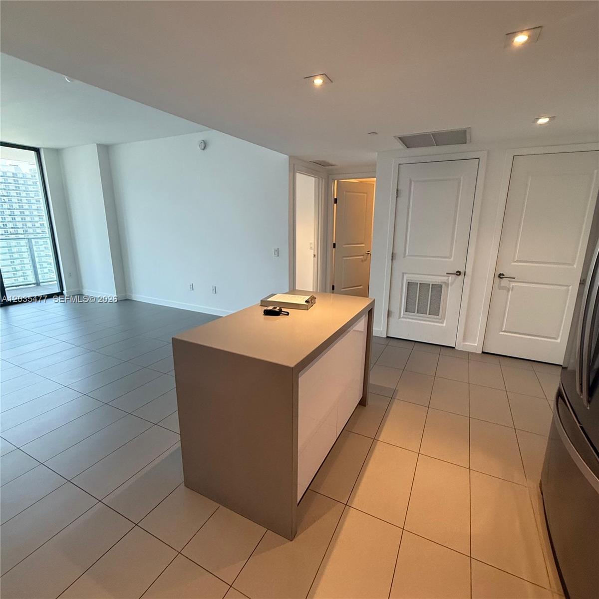 A modern kitchen island sits on a tiled floor in an open-concept living space — 1600 NE 1st Ave # 2607, Miami FL 33132, MIAMI, FL