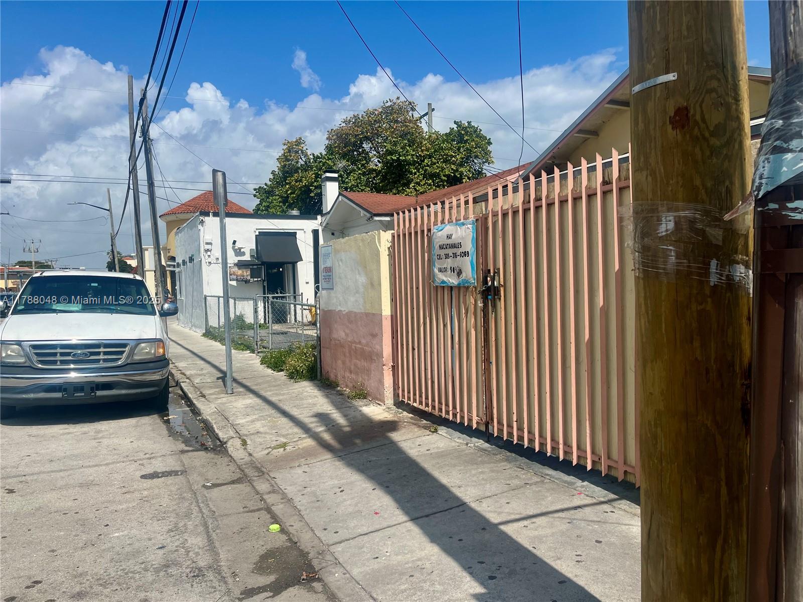 A white pickup truck is parked on a street next to a pink metal gate — 1574 SW 1st St, Miami FL 33135, MIAMI, FL