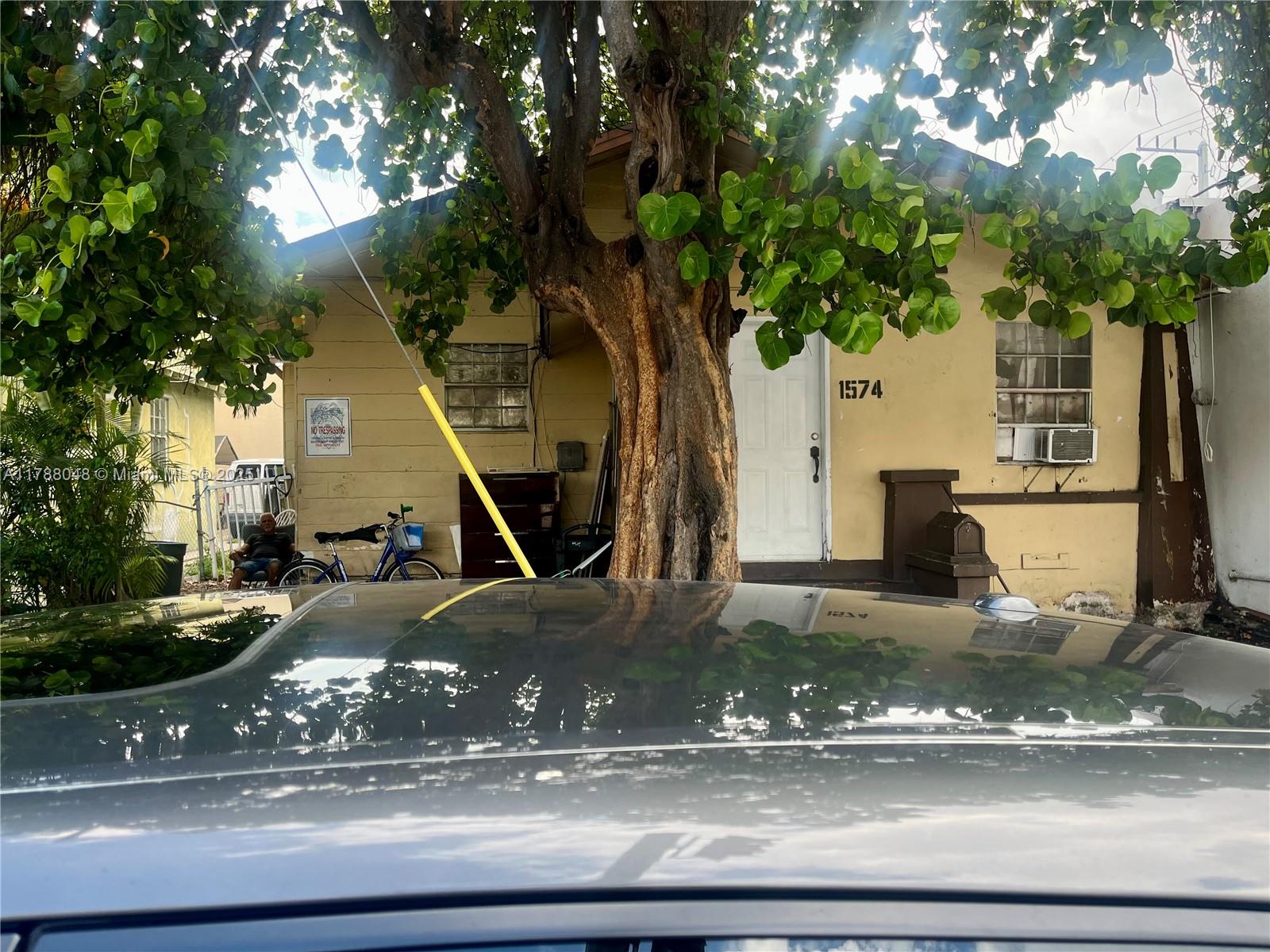 A yellow house exterior features a large tree in front and a white door — 1574 SW 1st St, Miami FL 33135, MIAMI, FL