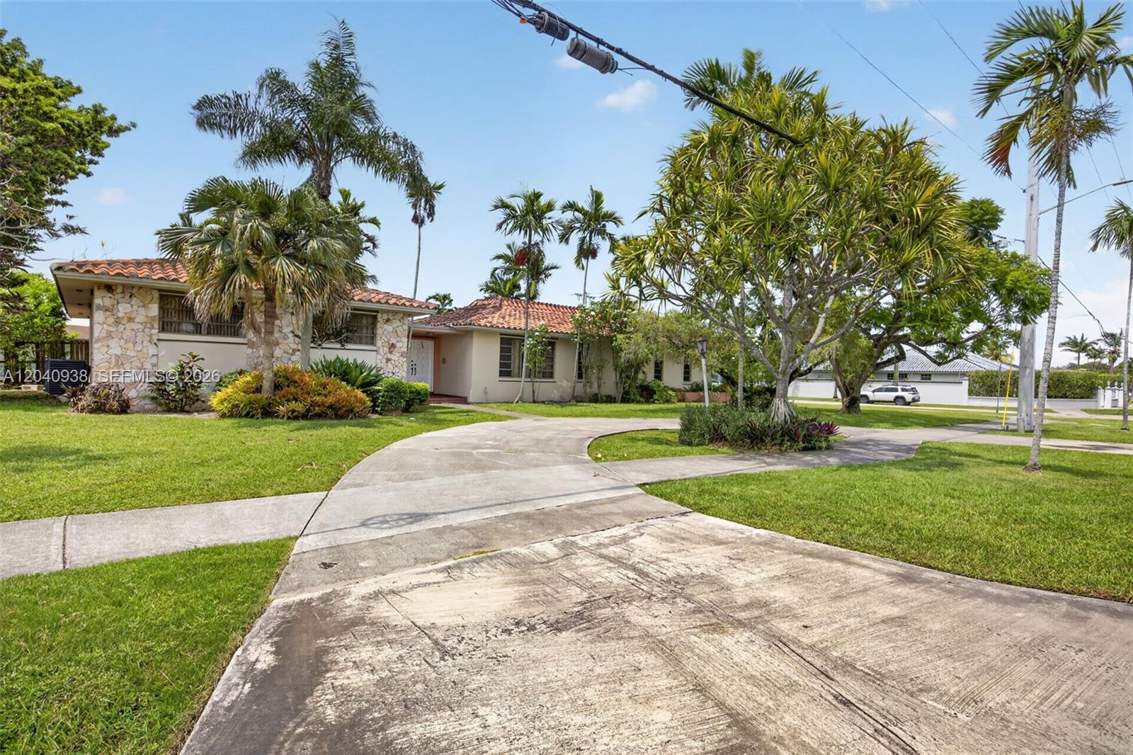 A single-story house with a stone facade and tile roof sits behind a concrete driveway — 11405 SW 32nd St, Miami FL 33165, MIAMI, FL