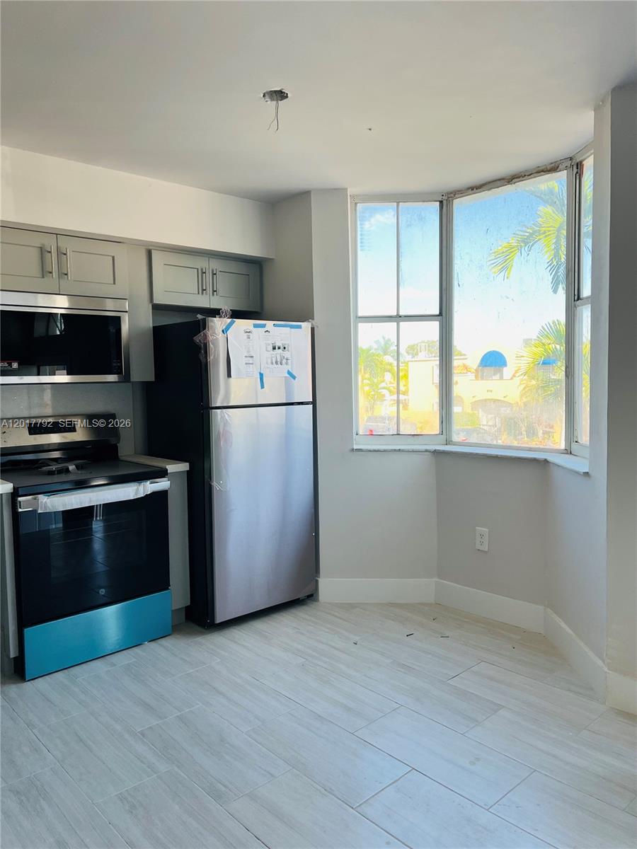 A kitchen features gray cabinets, stainless steel appliances, and a bay window with exterior views — 380 NW 85th Pl # 1406, Miami FL 33126, MIAMI, FL