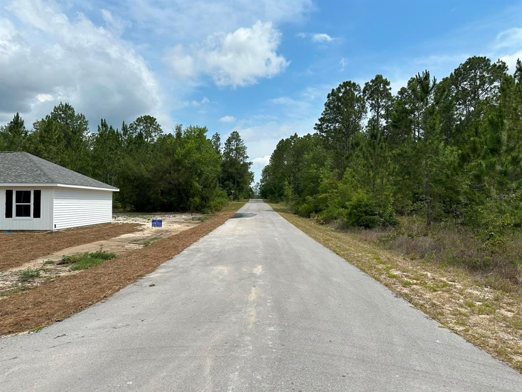A paved road leads through a wooded area past a newly constructed white house — 00 SOUTH HAVEN COURT, DUNNELLON, FL