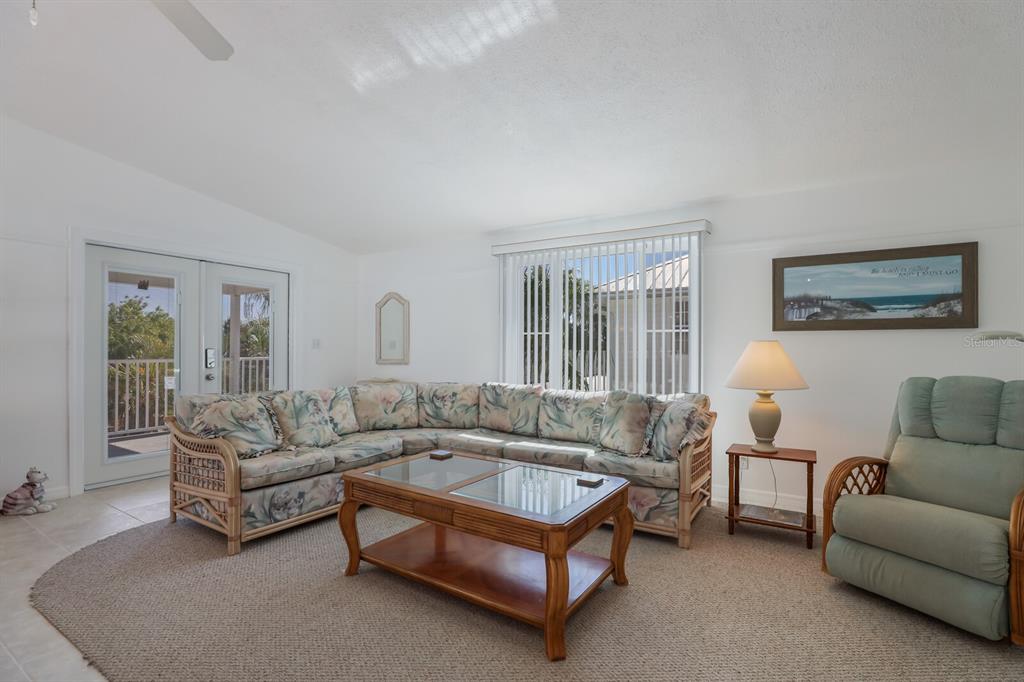A living room features a floral sectional sofa, a wooden coffee table, and a recliner — 2804 AVENUE C, HOLMES BEACH, FL