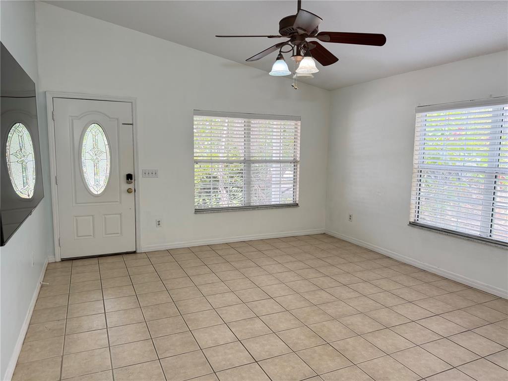 An empty room with tile flooring, a ceiling fan, and two windows with blinds — 414 ULELAH AVENUE, PALM HARBOR, FL