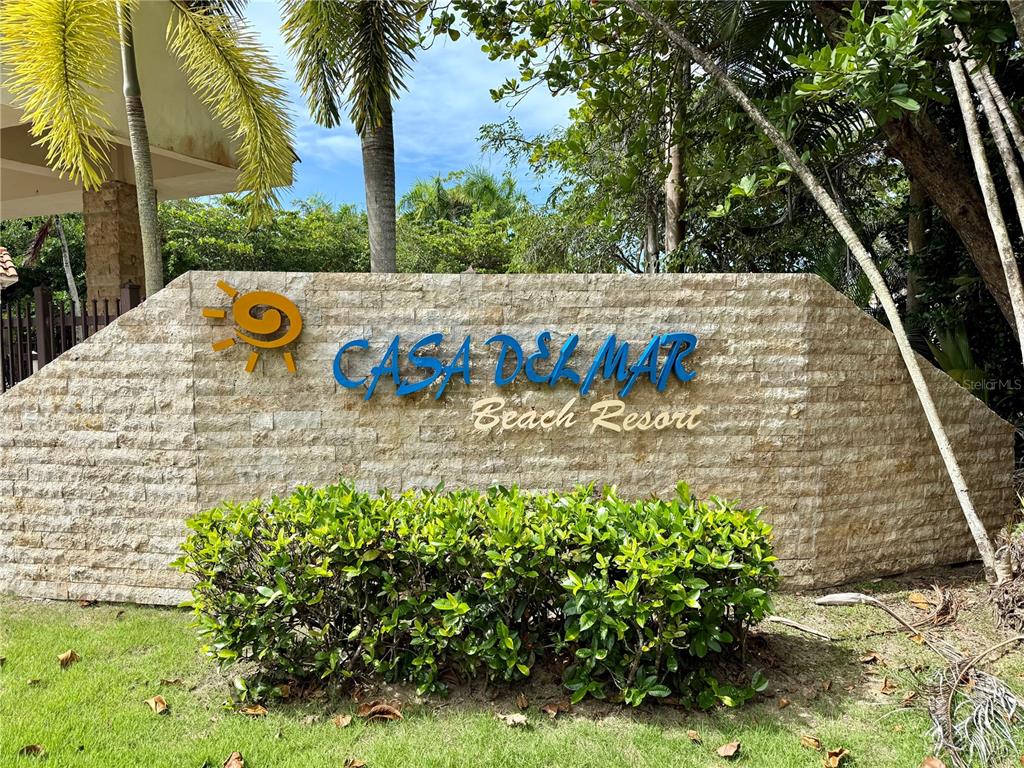 A stone sign for Casa Del Mar Beach Resort stands behind a green hedge — . CAMINO DE LAS PICUAS UNIT 2815, RIO GRANDE, PR
