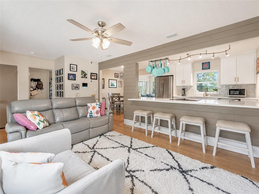 A living room with a gray sofa and a kitchen with a breakfast bar — 304 E JERSEY STREET, ORLANDO, FL