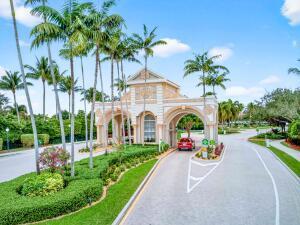 An arched stone entrance gate stands over a paved road lined with tall palm trees — 6504 Pisano Drive # 6504, Lake Worth FL 33467, LAKE WORTH, FL