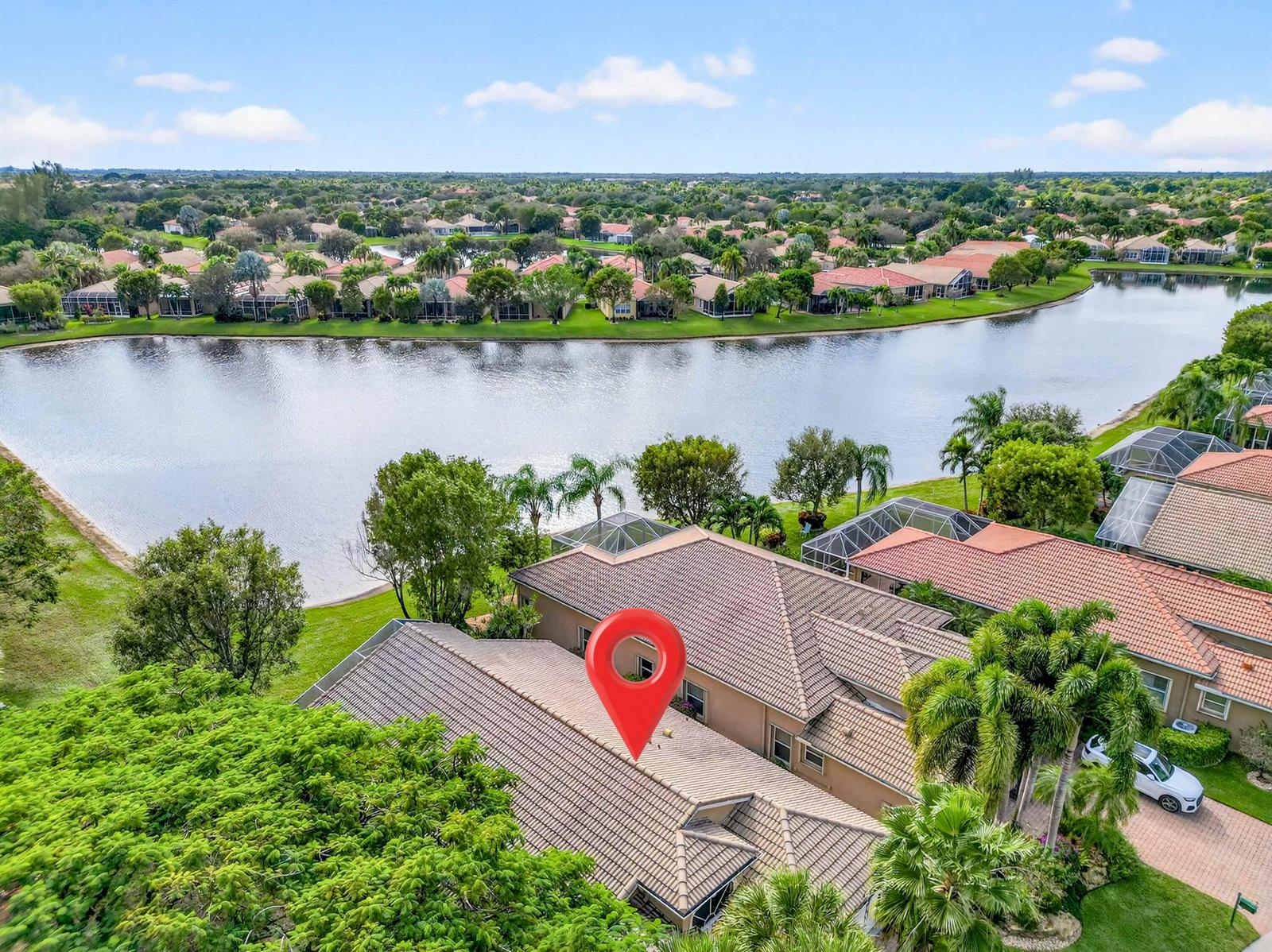 An aerial view of a suburban house with a tile roof overlooking a large lake — 6504 Pisano Drive # 6504, Lake Worth FL 33467, LAKE WORTH, FL