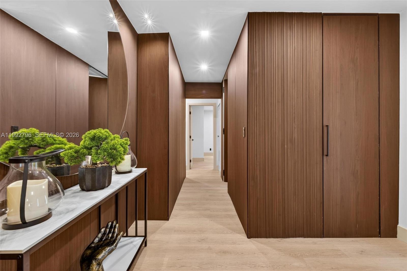 A hallway features wood-paneled walls, a console table with decor, and light-colored flooring — 14755 SW 18th Ct, Davie FL 33325, DAVIE, FL