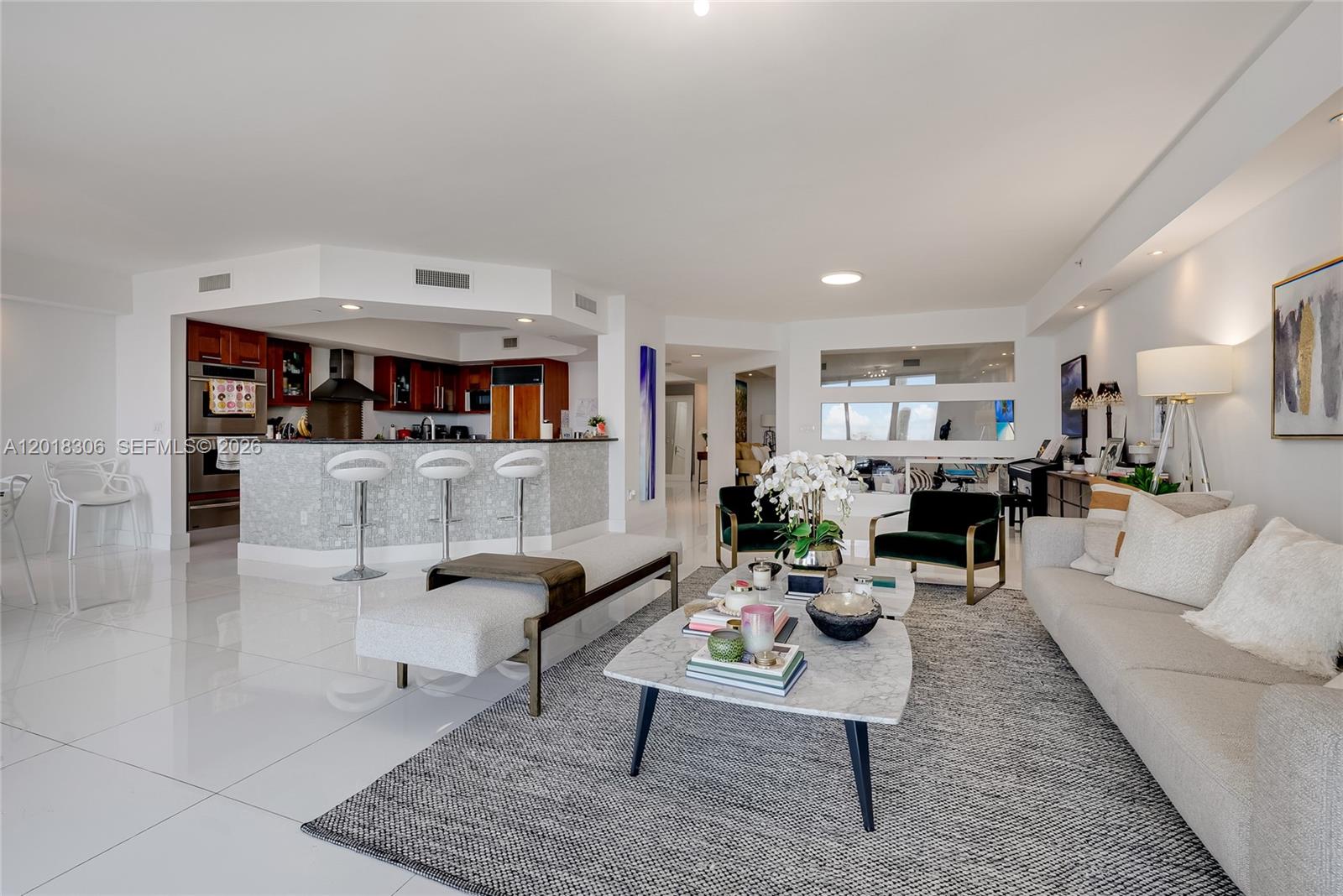 A modern open-concept living room features a kitchen island, white tile floors, and neutral furniture — 3301 NE 183rd St # 2007, Aventura FL 33160, AVENTURA, FL