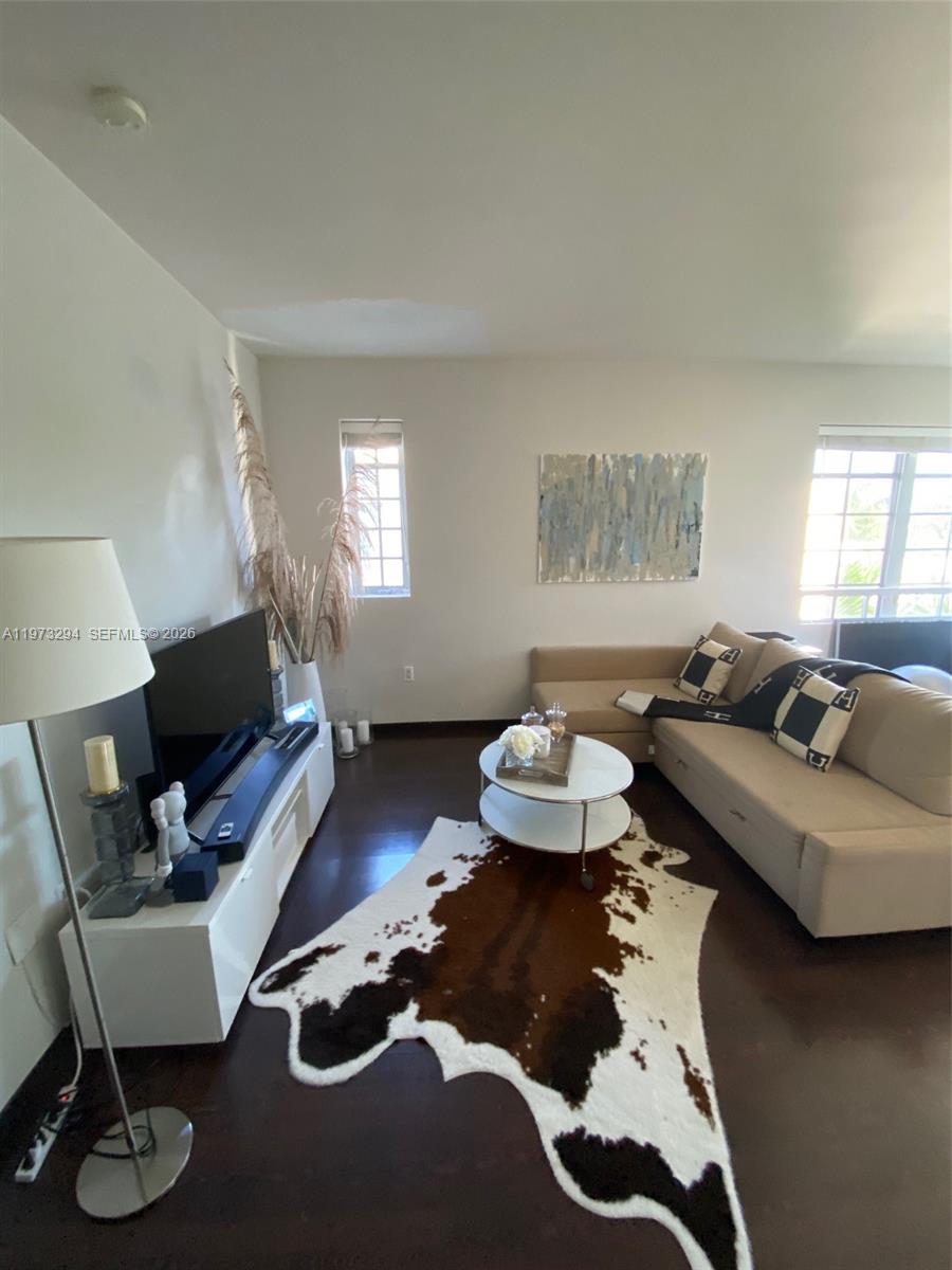 A living room features a beige sectional sofa, a cowhide rug, and a white media console — 435 21st St # 307, Miami Beach FL 33139, MIAMI BEACH, FL