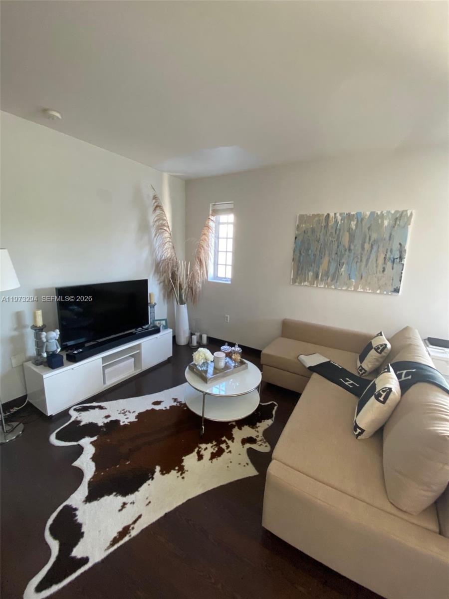 A living room features a beige sectional sofa, a white media console, and a cowhide rug — 435 21st St # 307, Miami Beach FL 33139, MIAMI BEACH, FL