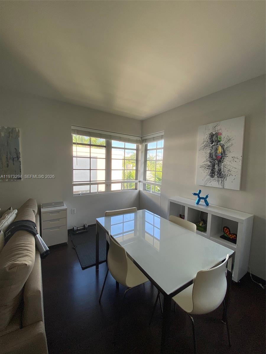 A dining area features a white glass table, modern chairs, and a corner window — 435 21st St # 307, Miami Beach FL 33139, MIAMI BEACH, FL