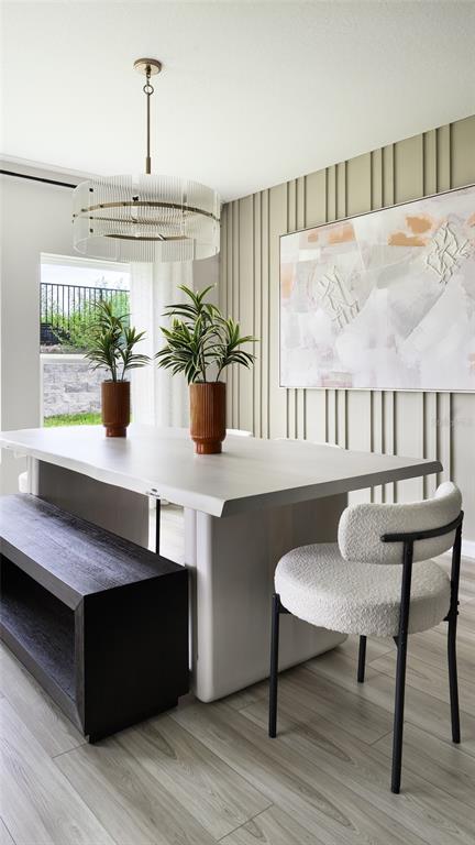 A dining room features a light-colored table, a dark bench, and a textured accent wall — 31699 BARONNE STREET, WESLEY CHAPEL, FL
